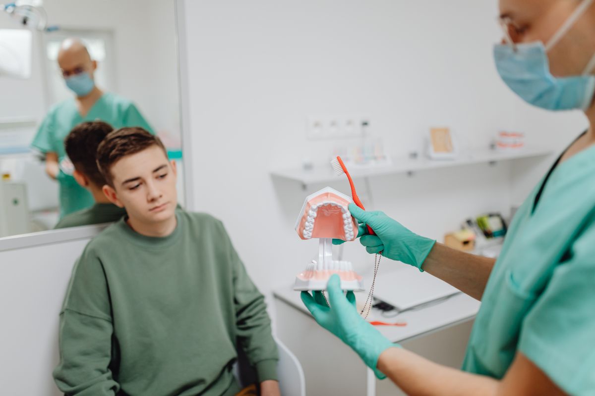 Dentist showing a patient a dental X-ray while discussing options to save a natural tooth instead of extraction