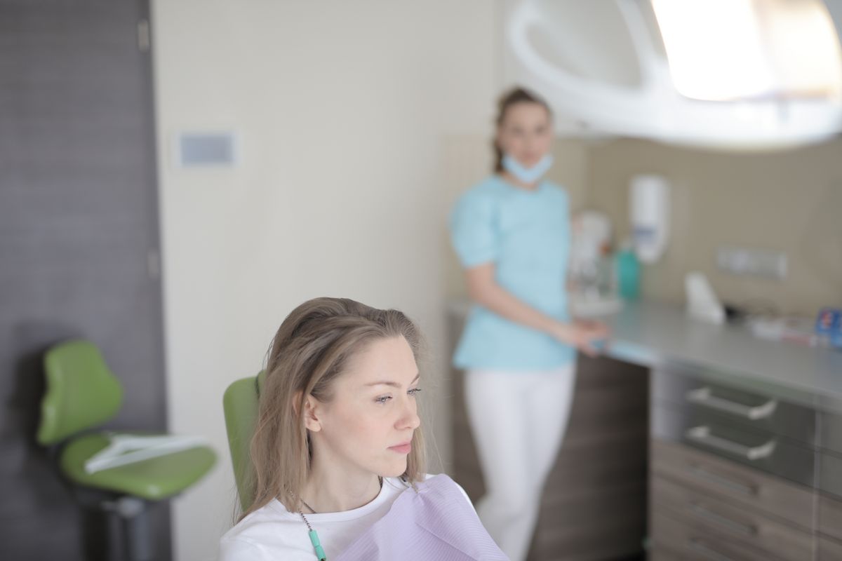 A thoughtful patient sitting in a dental chair considering their options